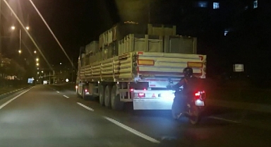 Kamyonun arkasına takılan motosiklet sürücüsü yürekleri ağza getirdi