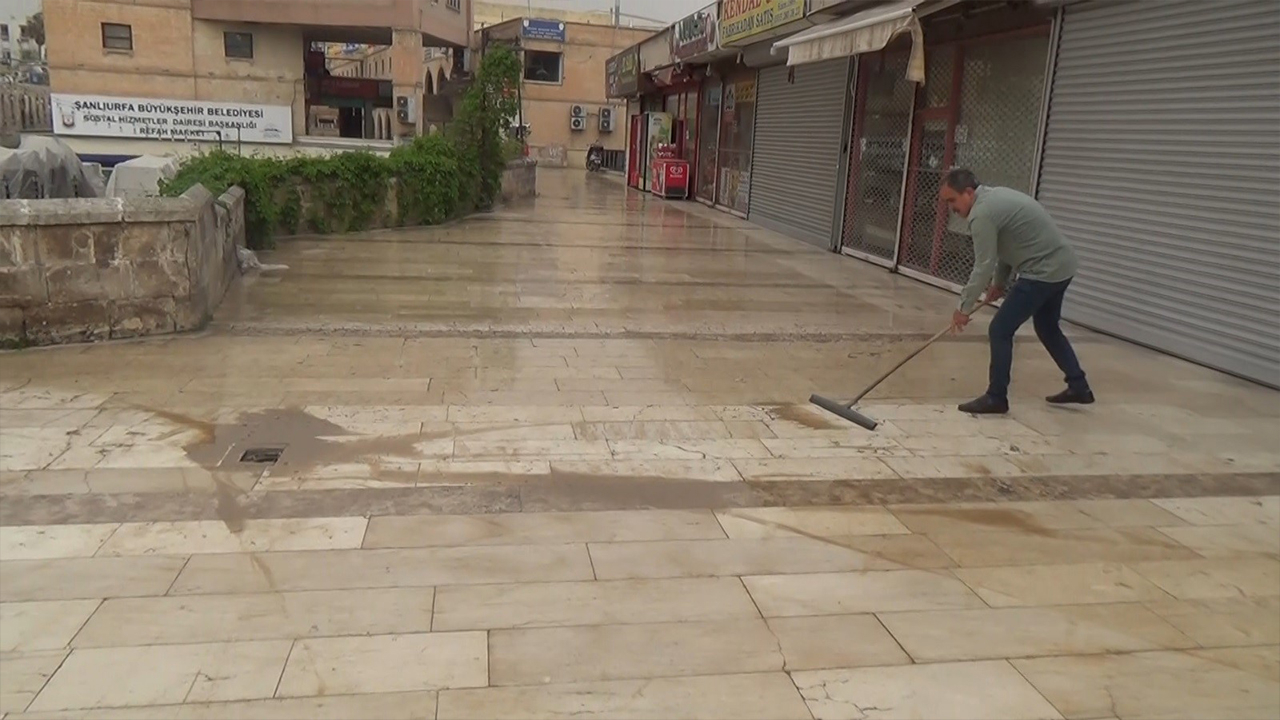 Şanlıurfa'da toz bulutu çamura dönüştü: Esnaf temizlikle başladı